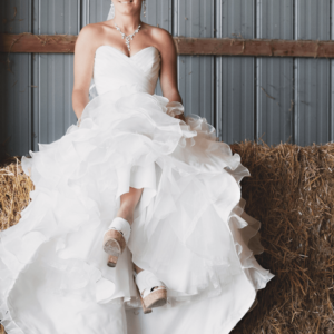 Image of bride sitting on hay at wedding venue